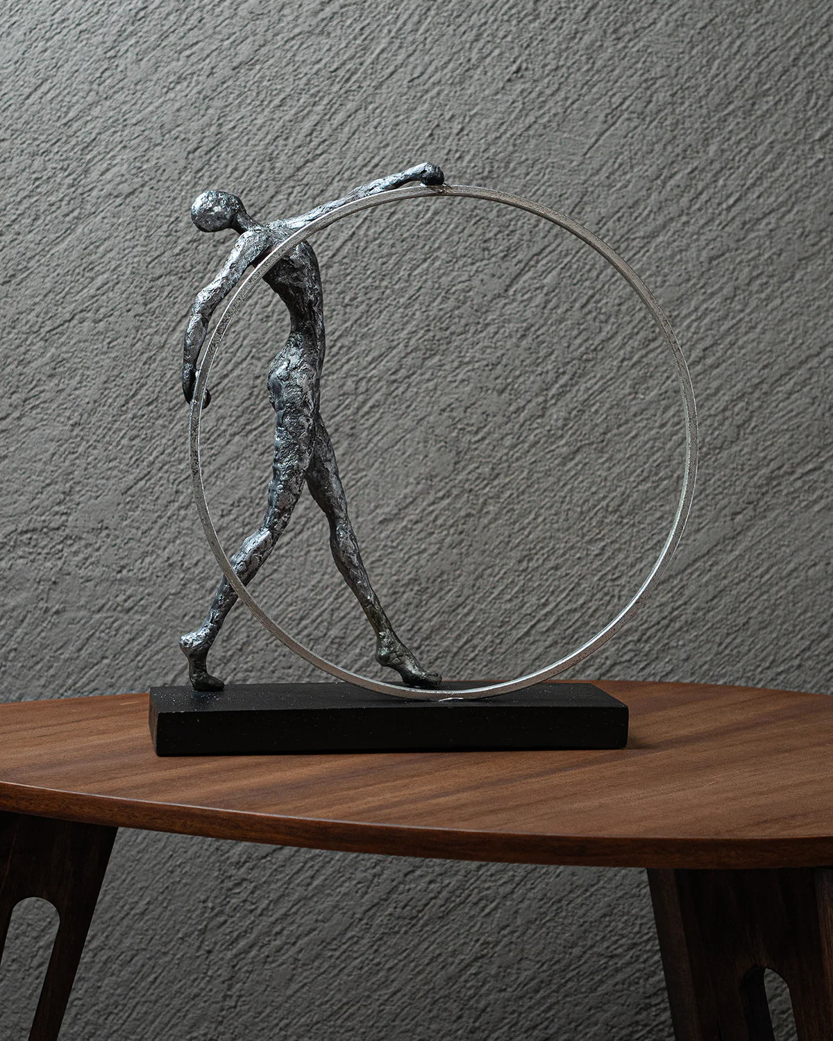 Escultura de hombre gimnasta con aro de plata